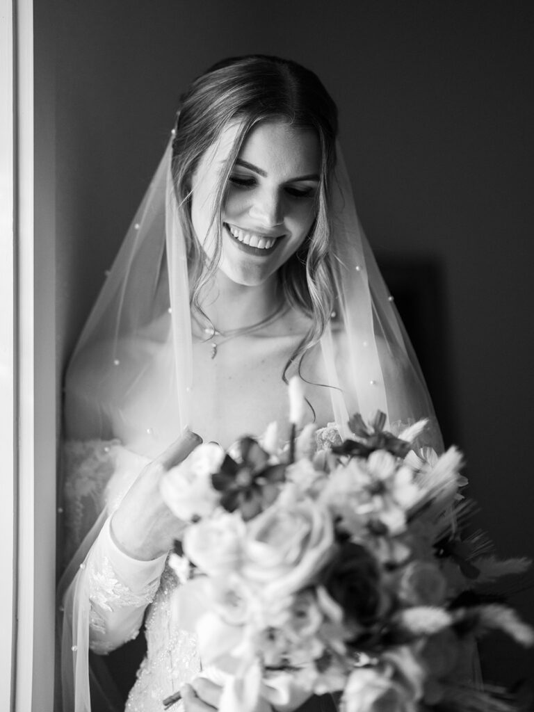 bride smiling with veil and bouquet