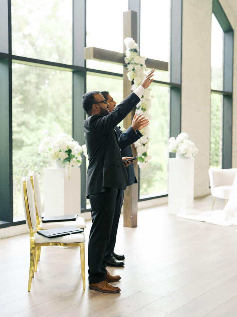 groomsmen worshipping during wedding ceremony
