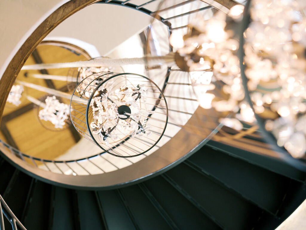 cinematic classy wedding photos of bride spinning a the bottom of spiral staircase