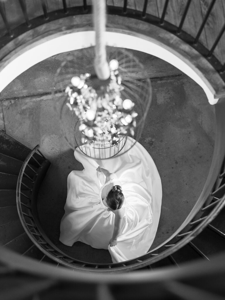 cinematic classy wedding photos of bride spinning a the bottom of spiral staircase