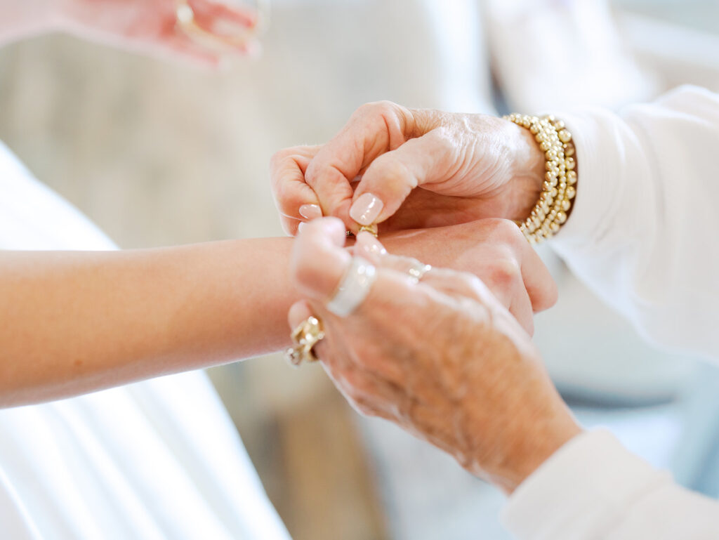 grandma helping bride put on her heirloom bracelet for bridal photos