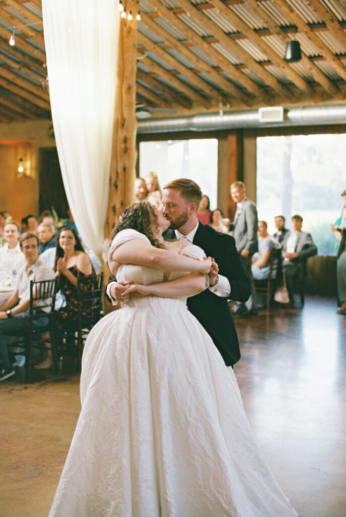 bride and groom kissing on wedding day captured through wedding photography on film