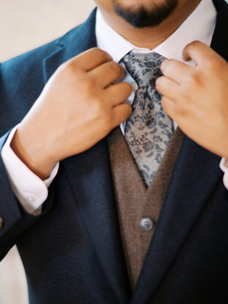 getting ready wedding photos groom adjusting his tie