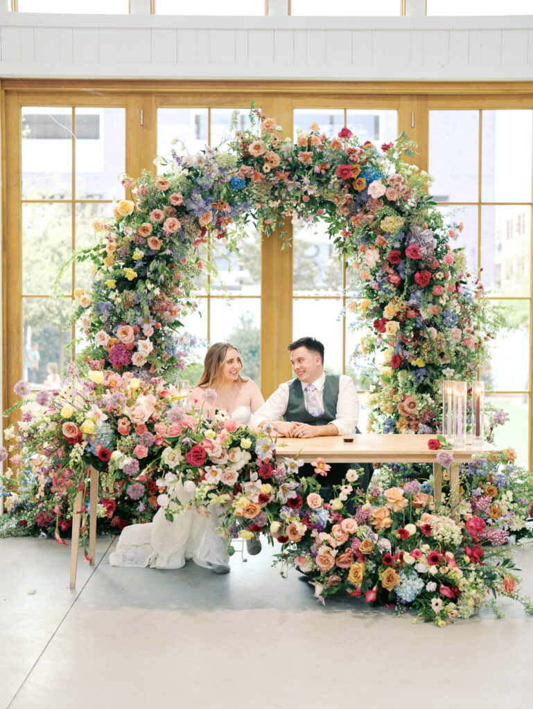 bride and groom surrounded by florals at wedding in austin
