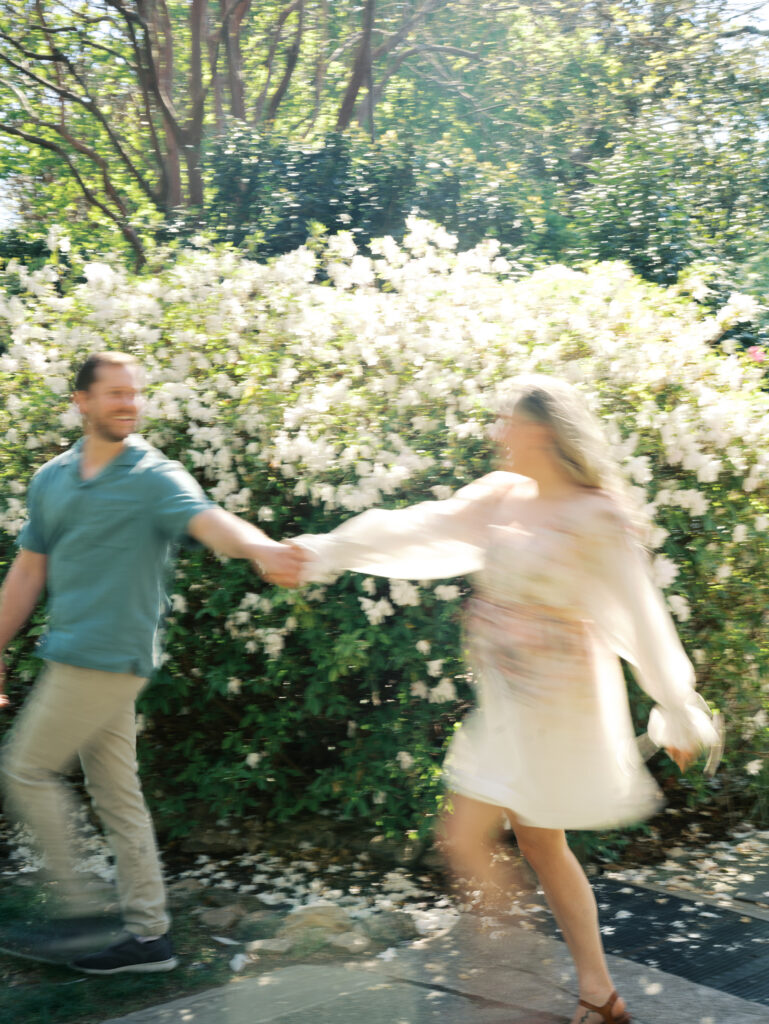 man and woman dancing in garden engagement session