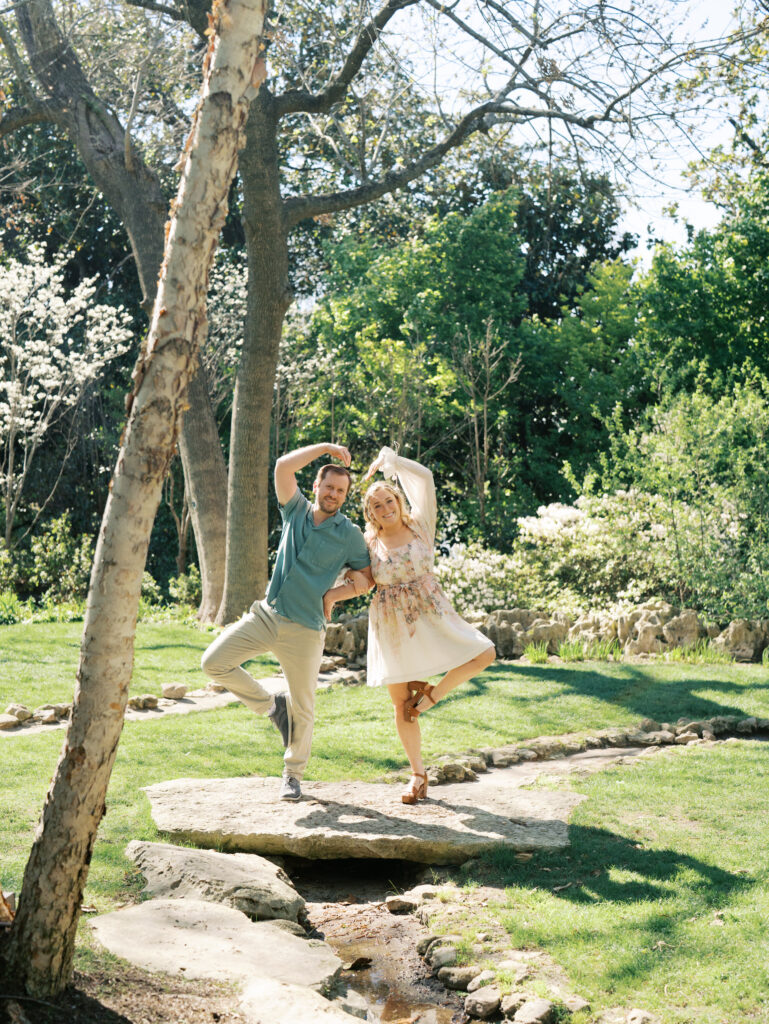 man and woman dancing during engagement session in Texas garden 
