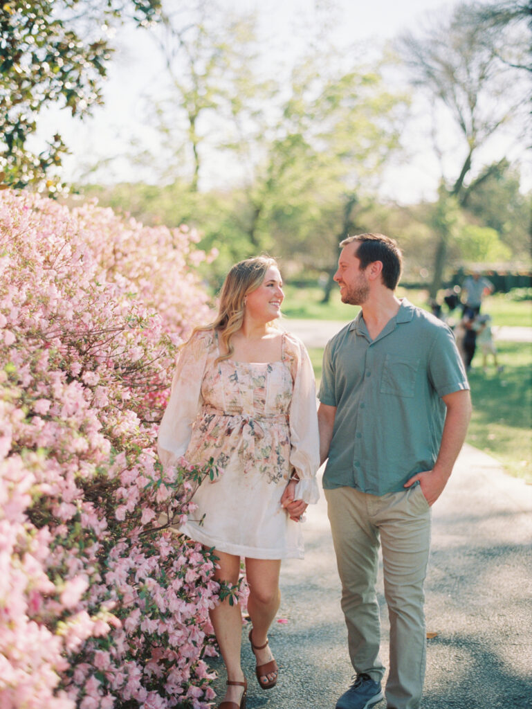 couple holding hands in garden for spring engagement session