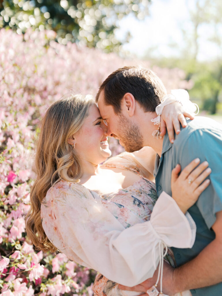 couple smiling nose to nose in a garden for their spring engagement session 