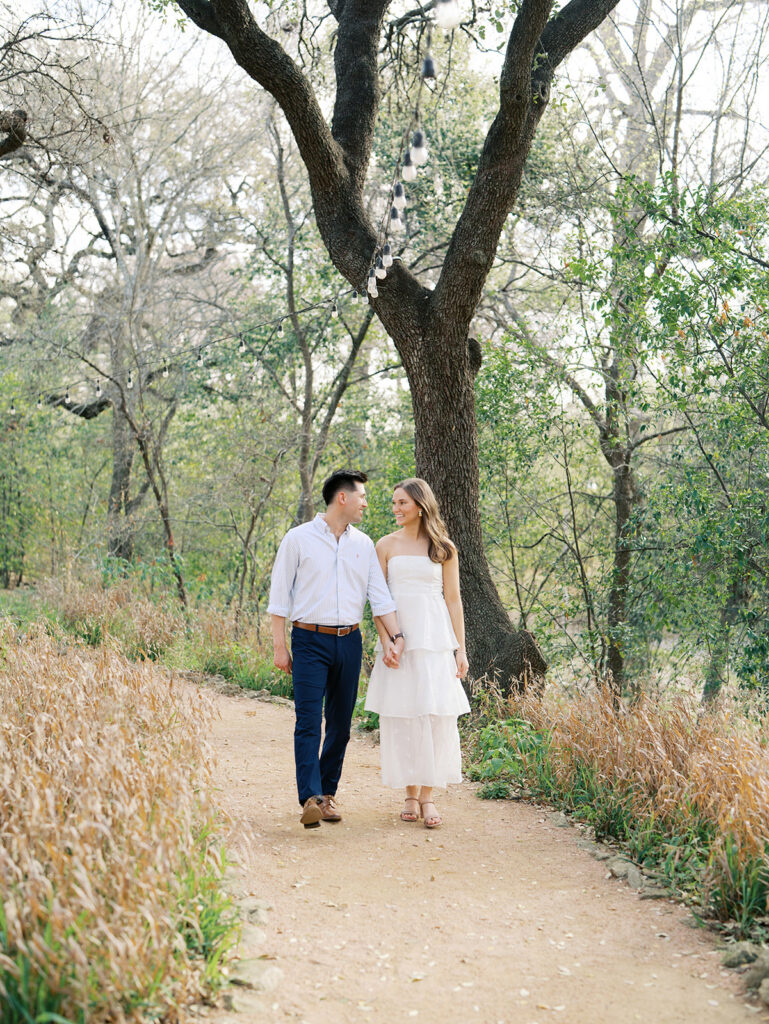 couple smiling and holding hands at a park