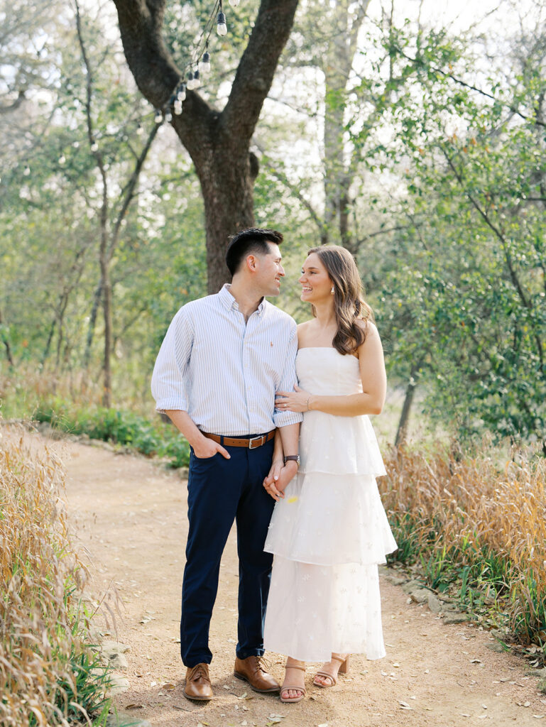 couple smiling and holding hands at a park