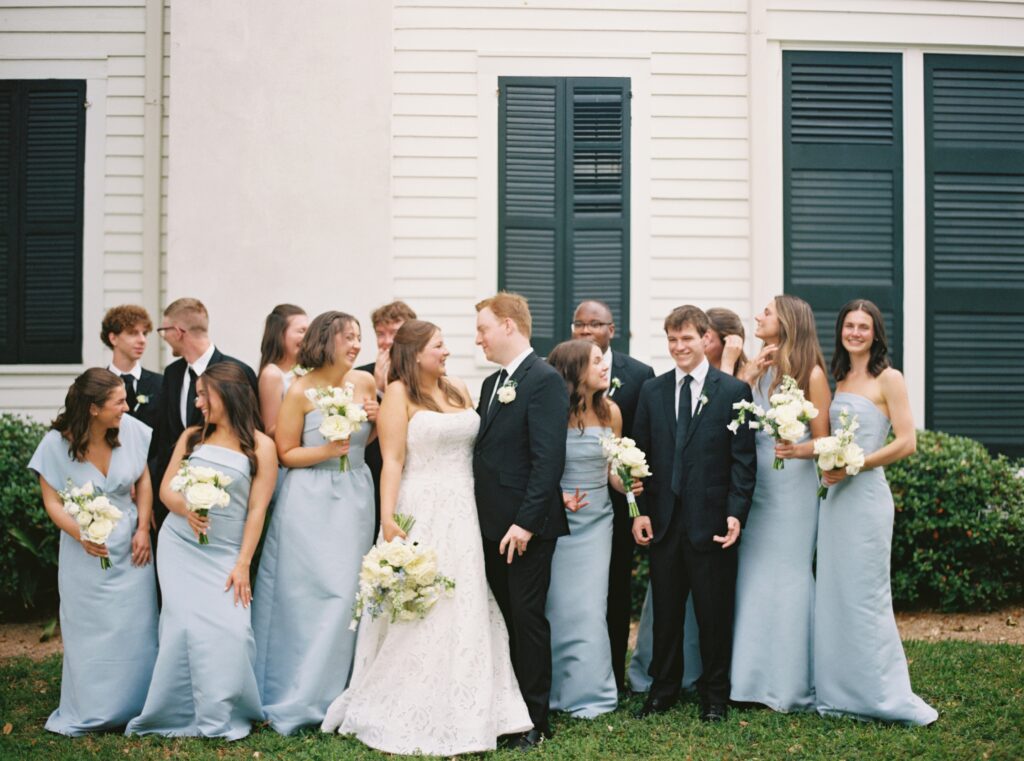 bridal party on wedding day with bride and groom in center smiling. galveston wedding