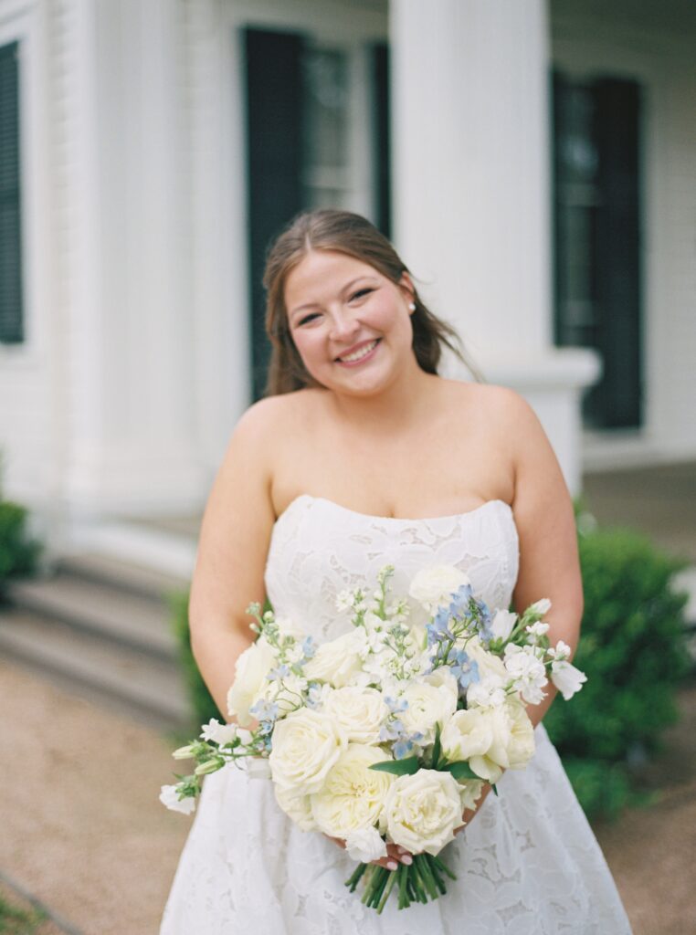 bride smiling on wedding day with florals 