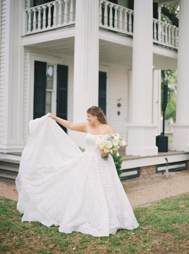 bride throwing the train of her dress and holding flowers 