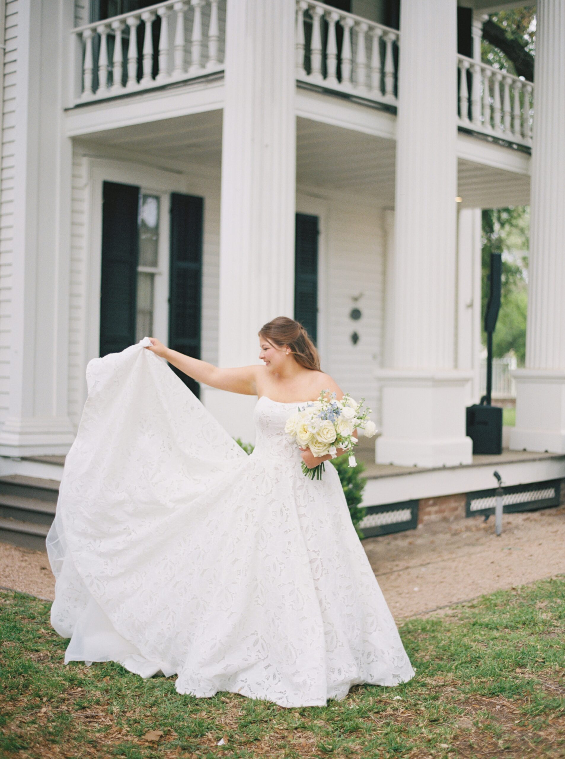bride throwing the train of her dress and holding flowers