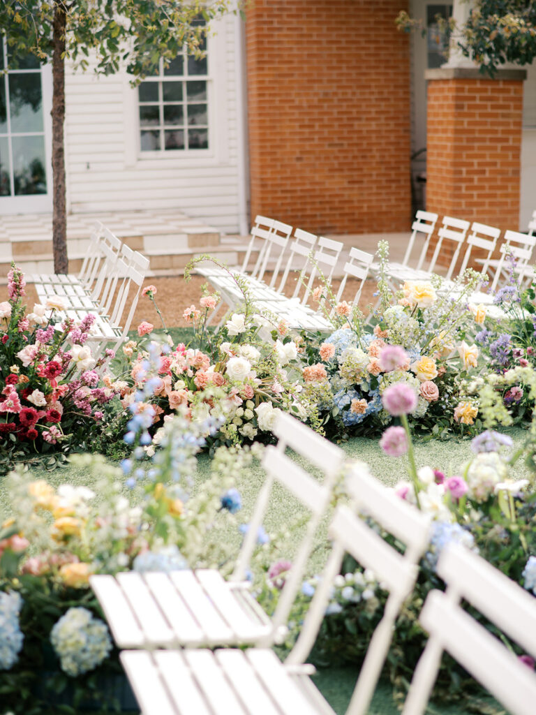 colorful spring wedding aisle flowers on film in austin texas at wish well house