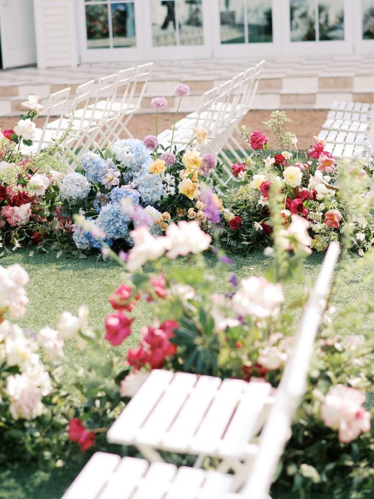 colorful spring wedding aisle flowers on film in austin texas at wish well house
