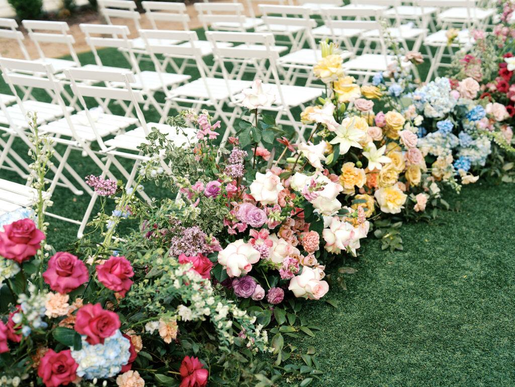colorful spring wedding aisle flowers on film in austin texas at wish well house