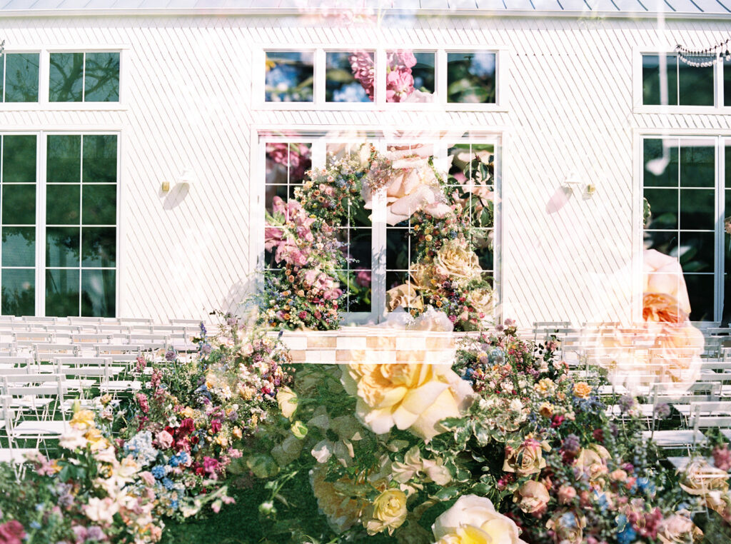 film photography double exposure of vibrant wedding flowers lining the aisle and a spring wedding arch